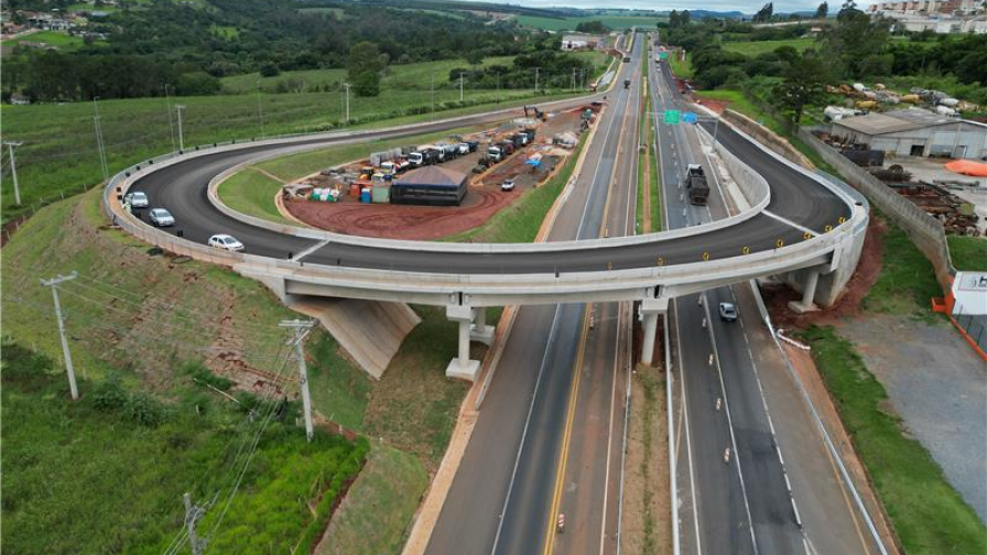 Perspectiva aérea de uma rodovia, com obras e a infraestrutura em desenvolvimento as margens da rodovia.