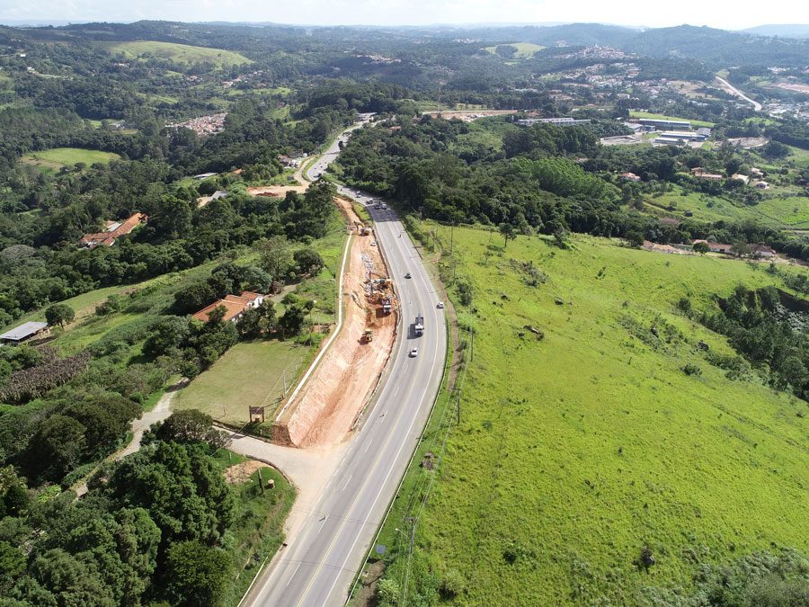 Perspectiva aérea da construção de uma estrada, com obras e a infraestrutura em desenvolvimento as margens da rodovia.