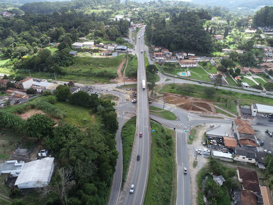 Perspectiva aérea da construção de uma estrada, com obras e a infraestrutura em desenvolvimento as margens da rodovia.