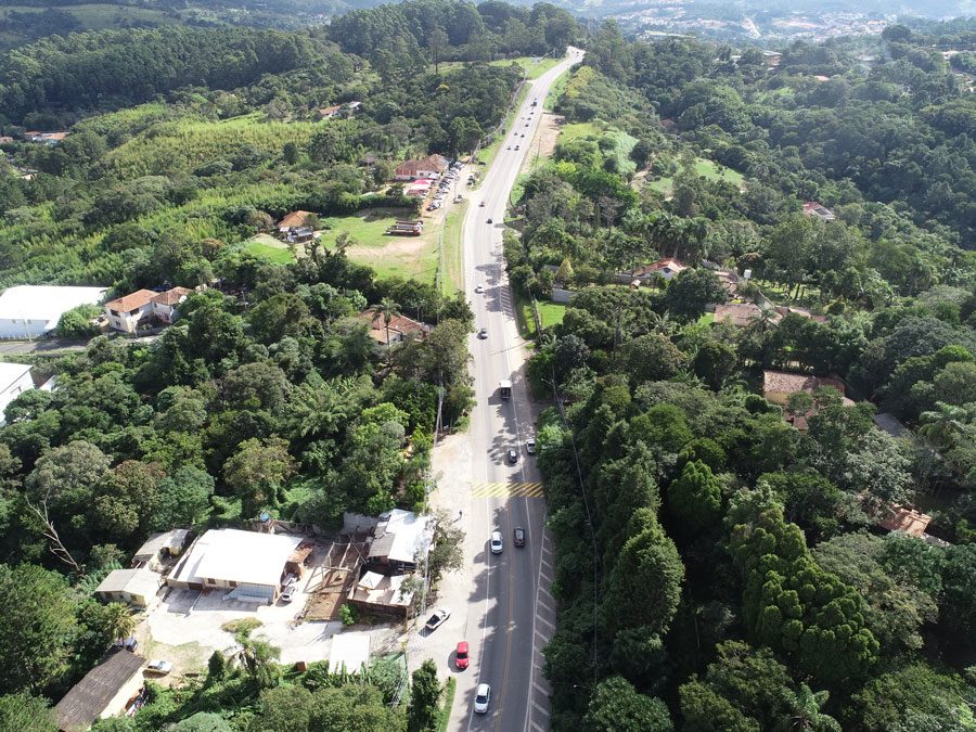 Perspectiva aérea da construção de uma estrada, com obras e a infraestrutura em desenvolvimento as margens da rodovia.