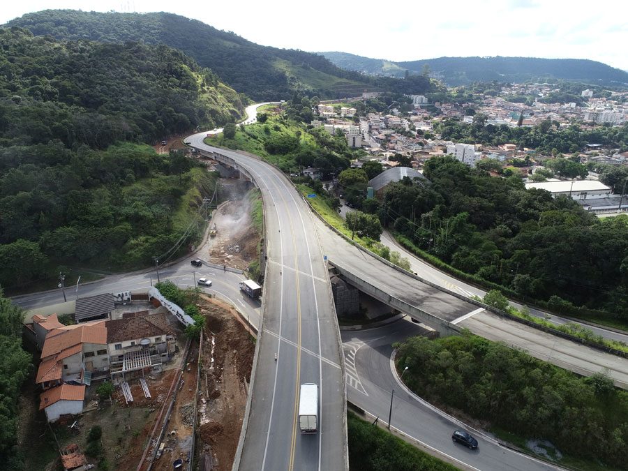 Perspectiva aérea da construção de uma estrada, com obras e a infraestrutura em desenvolvimento as margens da rodovia.