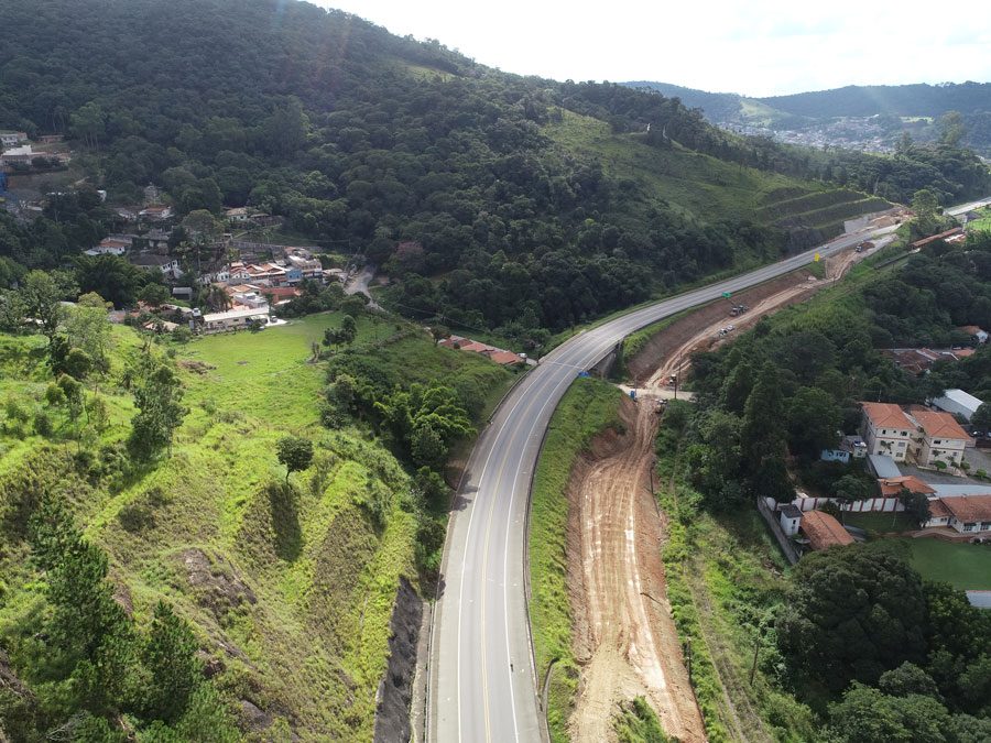 Perspectiva aérea da construção de uma estrada, com obras e a infraestrutura em desenvolvimento as margens da rodovia.