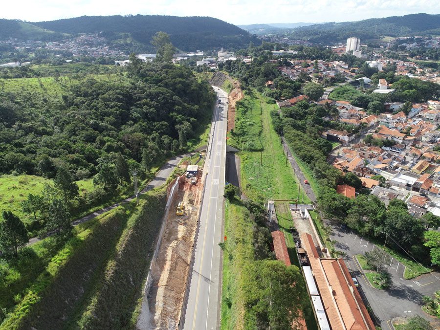 Perspectiva aérea da construção de uma estrada, com obras e a infraestrutura em desenvolvimento as margens da rodovia.