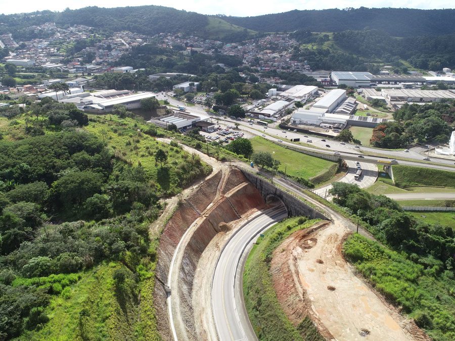 Perspectiva aérea da construção de uma estrada, com obras e a infraestrutura em desenvolvimento as margens da rodovia.