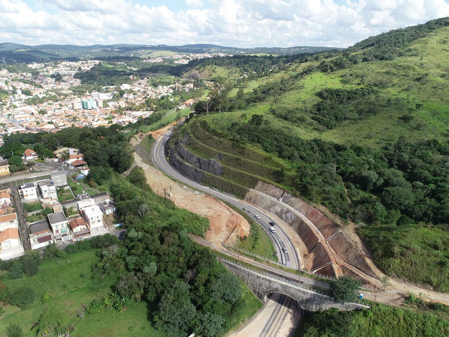 Perspectiva aérea da construção de uma estrada, com obras e a infraestrutura em desenvolvimento as margens da rodovia.