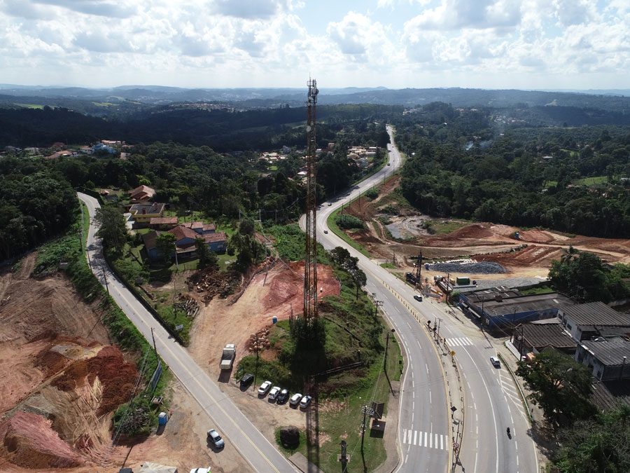 Perspectiva aérea da construção de uma estrada, com obras e a infraestrutura em desenvolvimento as margens da rodovia.