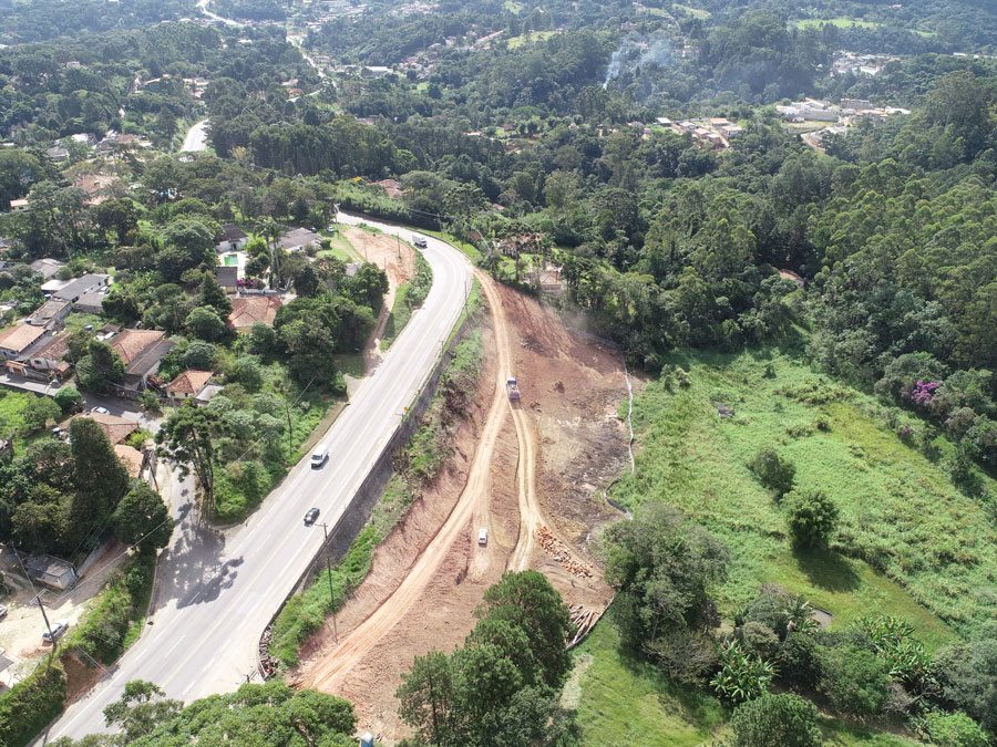 Perspectiva aérea da construção de uma estrada, com obras e a infraestrutura em desenvolvimento as margens da rodovia.