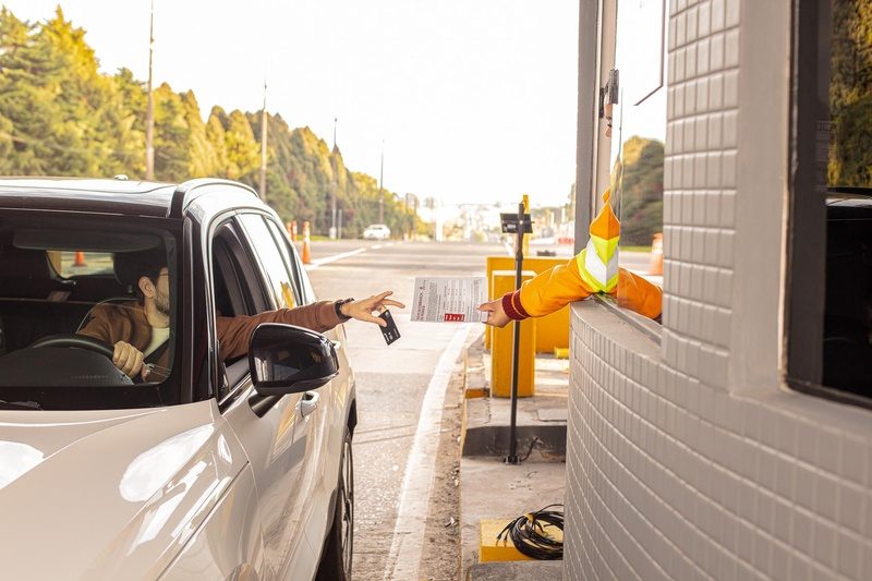 Colaborador da CCR PRVias entrega a motorista um folheto com orientações sobre início da cobrança de pedágio durante operação pré-assistida - Crédito: Comunicação CCR PRVias