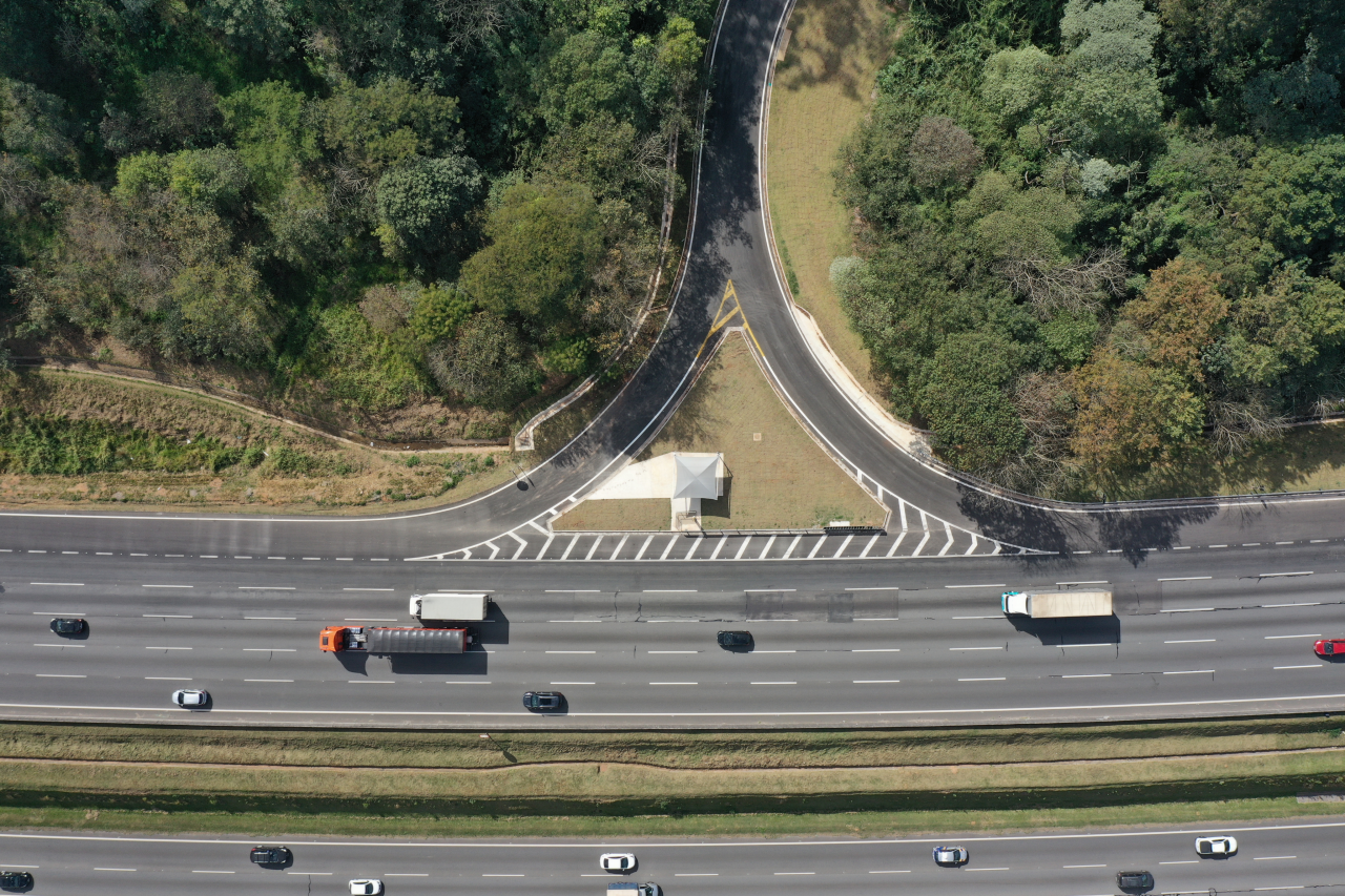 Vista superior de rodovia administrada pela CCR, com vias de acessos à faixa de domínio